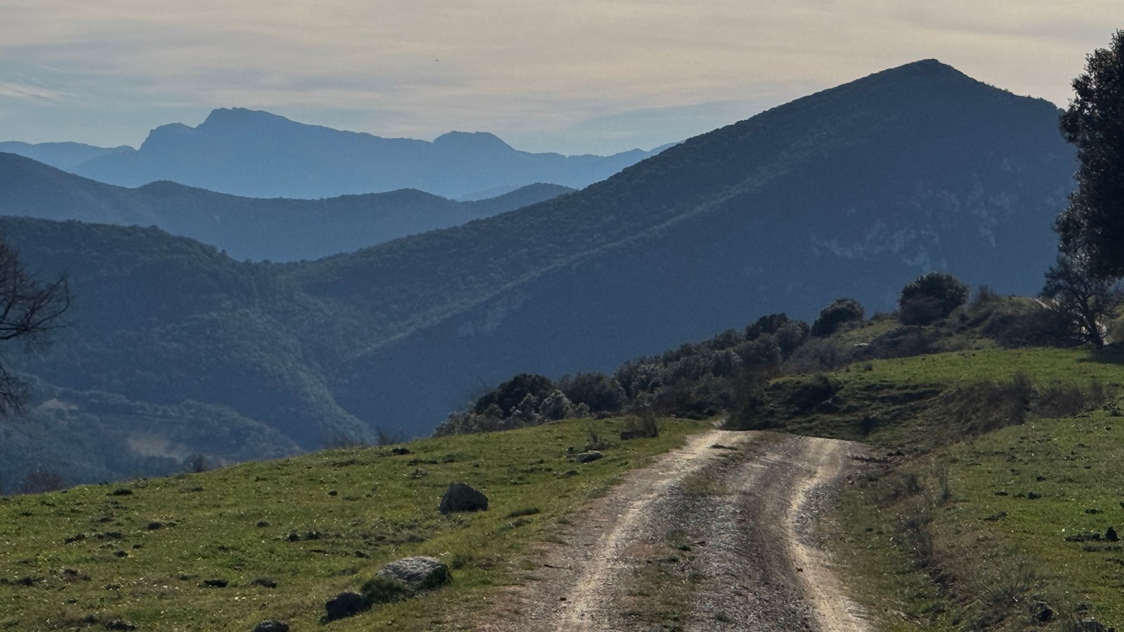 Sentier escarpé bordé de pierriers montant vers les crêtes pyrénéennes